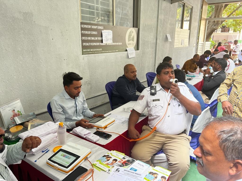A Bengaluru traffic police officer undergoing a spirometry lung function test at a VORIC roadside screening camp